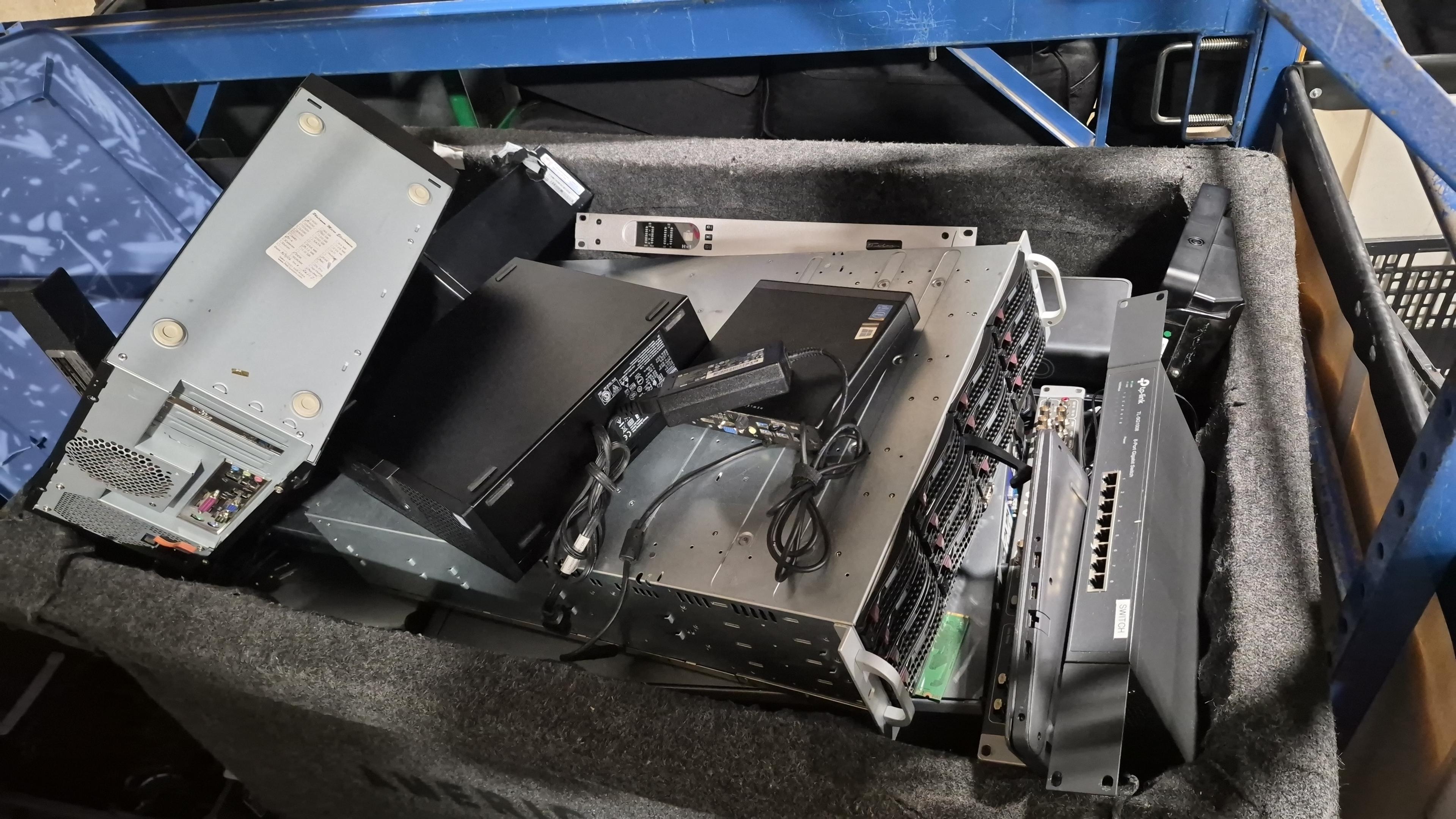 Servers, switches, and network gear staged in a cart for recycling